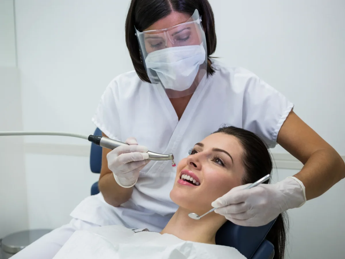 Dentist Examining Female Patient With Tools